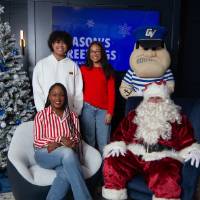 Teenagers with mom smile with Santa and Louie